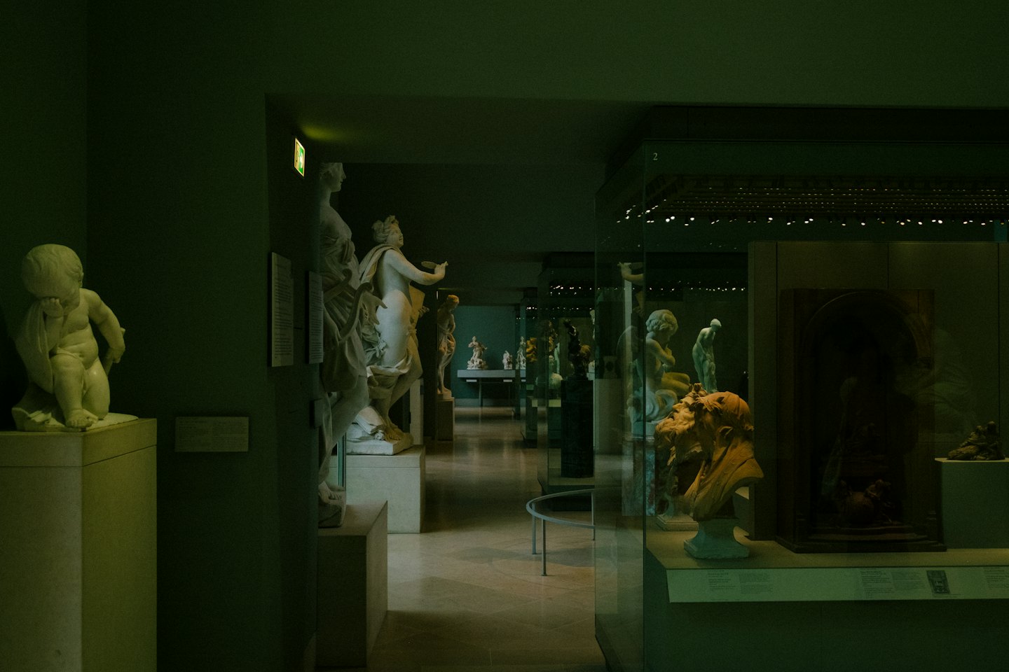 Sculture e busti classici esposti in un lungo corridoio di museo.