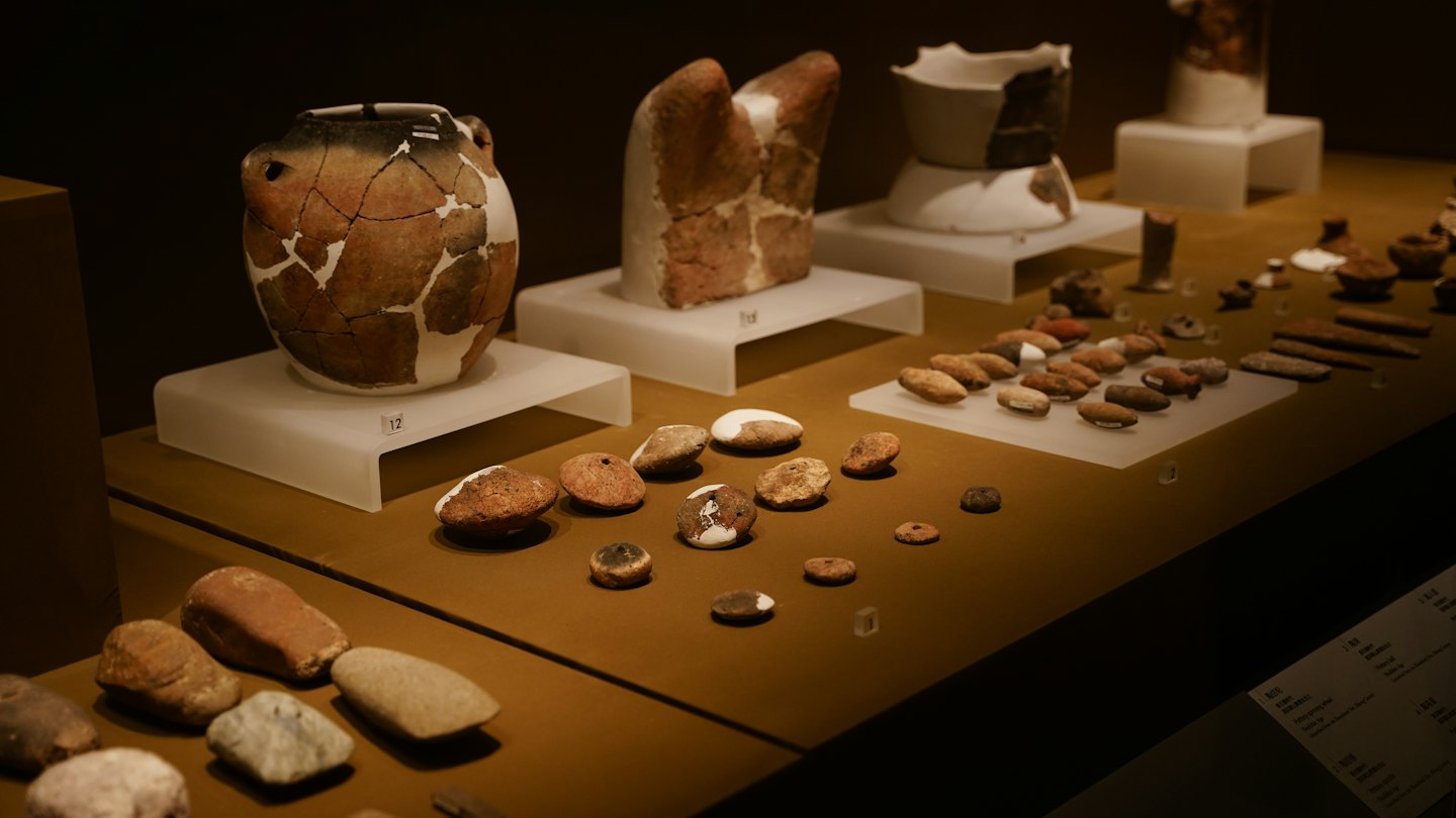 Antichi manufatti in ceramica e pietra esposti in un museo.