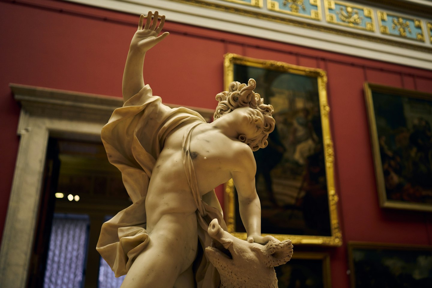 Statua di marmo di un uomo che lotta con un cinghiale.